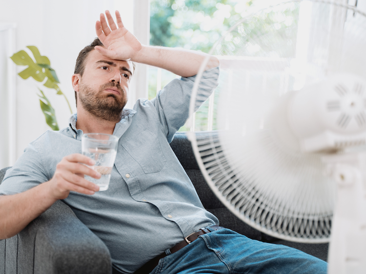 Photo d'un homme devant un ventilateur lors d'une canicule